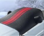 Glossy black carbon fiber sunshade with red stripes for car windshield, designed to block heat and UV rays, providing protection and style during winter or summer drives.